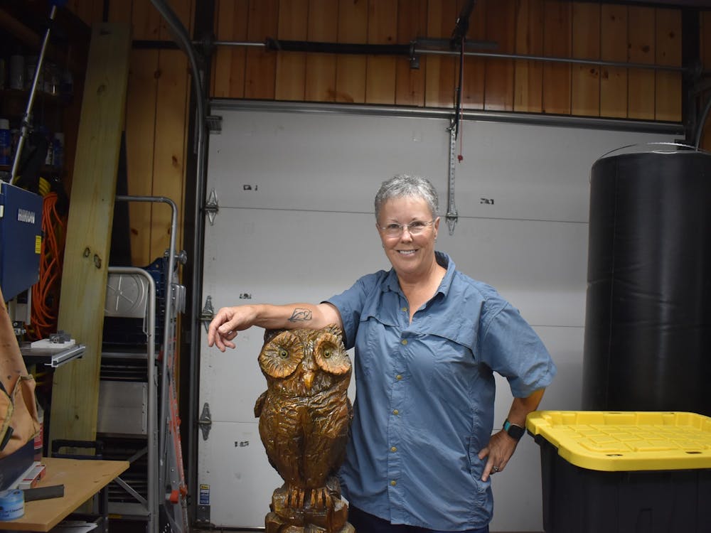 Alexis Pruitt stands with carved owl Artemis on September 6, 2023, in her workshop. She makes tools in her workshop, including pens. 