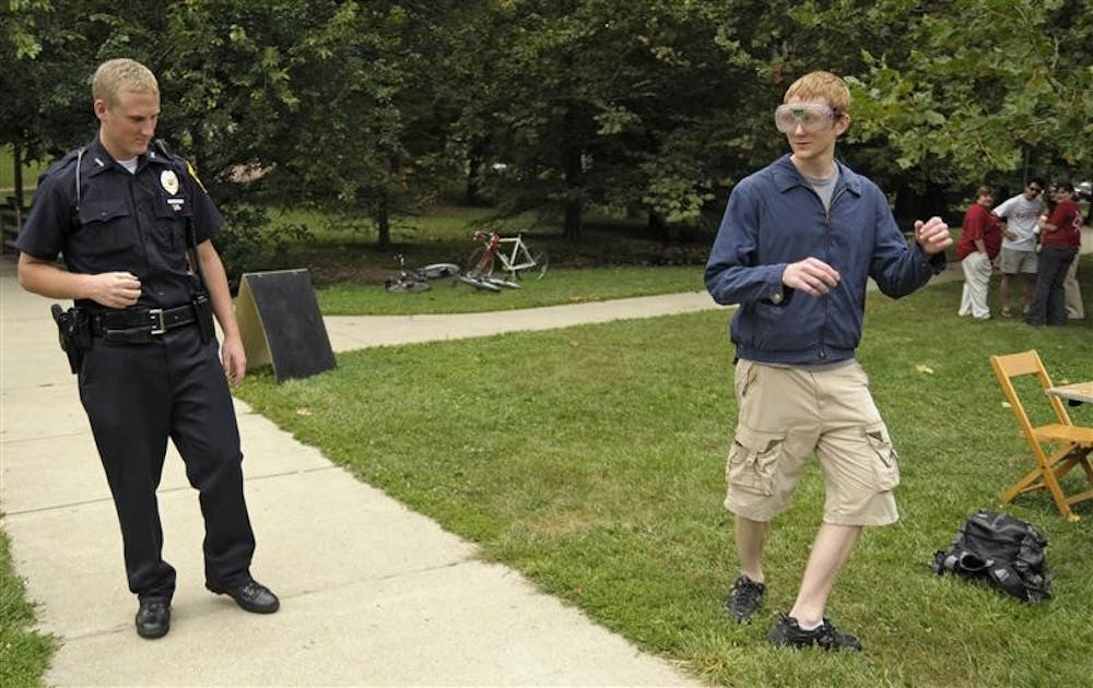 IUPD officer Mark Molter issues a field sobriety test to Mark Sliva, junior, who is wearing beer goggles to simulate the visual effects of alchohol consumption Friday afternoon at Sex, Drugs, and Rock and Roll in Dunn Meadow.