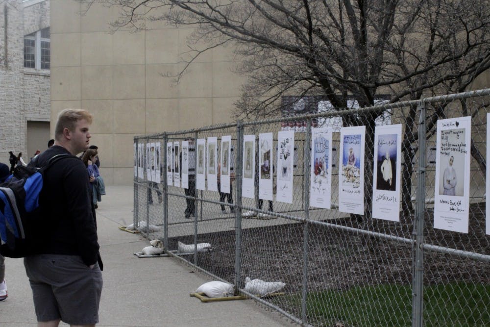 <p>Kade Padgett, Late Nite director at the Indiana Memorial Union Board, looks at refugee posters.</p>
