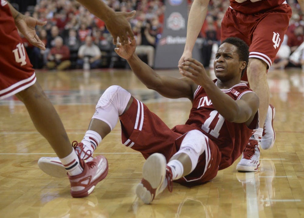 Junior guard Kevin "Yogi" Ferrell is helped up by his teammates after being knocked down during IU's game against Ohio State on Sunday at Value City Arena at the Jerome Schottenstein Center.