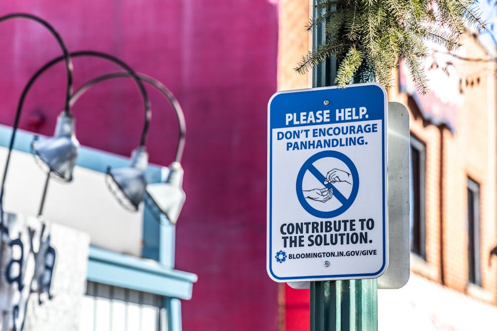 <p>A City of Bloomington sign discouraging panhandling is seen Dec. 12, 2021, on Kirkwood Avenue. Beacon, a nonprofit organization providing housing and social services to Bloomington residents in poverty, will not open a temporary shelter this winter after opening one last year.</p>