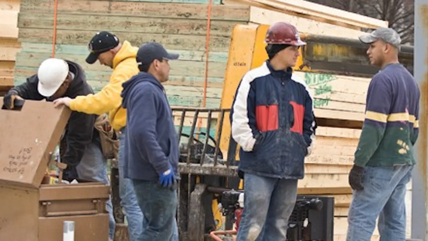 Workers look for chain to secure an air compressor at the Hutton Honors College construction site. Valuable tools that are not secured may be stolen.