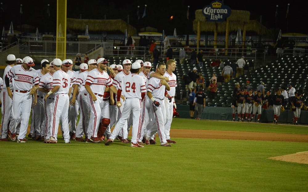 Teammates throw thier arms around Freshman Matt Gorski's neck and congratulate him for his game winning hit Tuesday night. After 10 innings the Hoosiers beat Ball State 4-3. 
