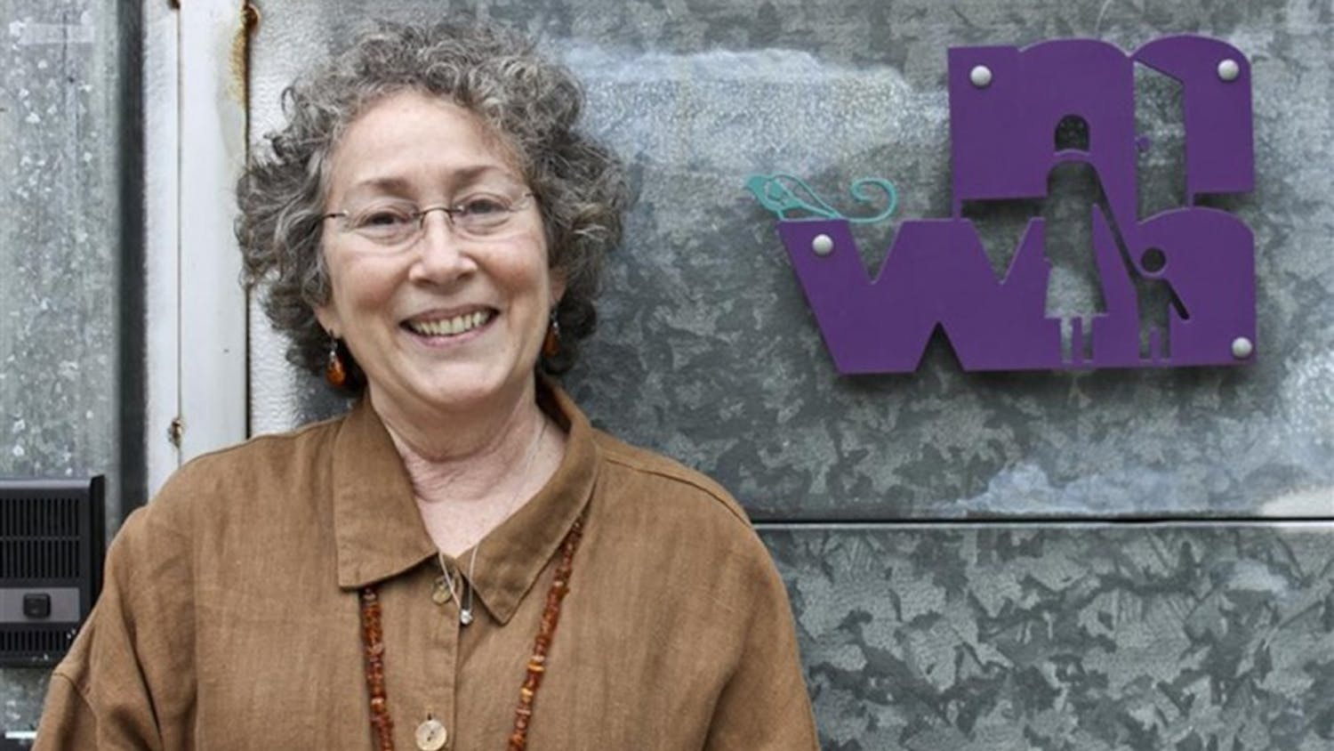 Toby Strout, director of Middle Way House for 30 years, stands in front of the nonprofit organization's building. Strout died this month at age 71.