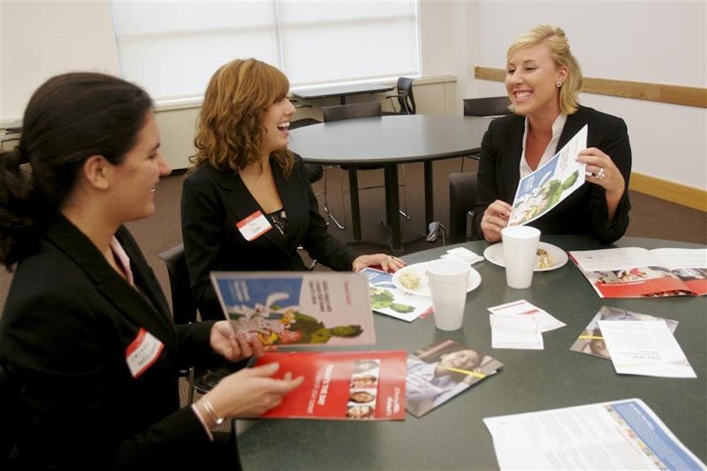 Freshmen Caitlin Williams, Tess Bedel, and Lindsay Edwards look through pamphlets that were give out by various companies at an event sponsored by the Undergraduate Black MBA Association Tuesday evening at the Kelley School of Business. The corporate networking fair brought together campus represenatives from companies such as General Mills, Target, and Ernst & Young. 