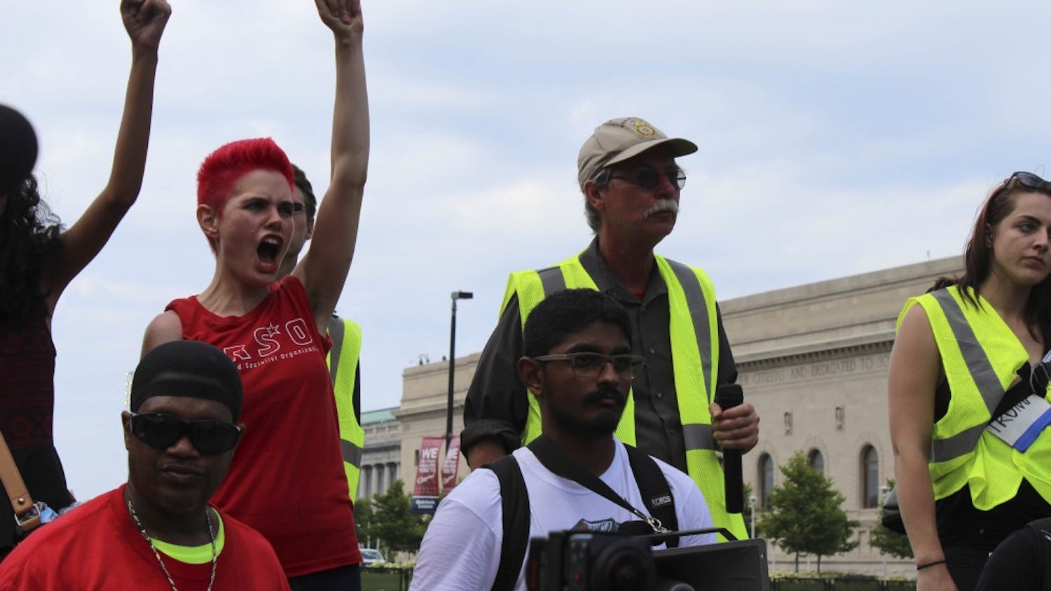 Kait McIntyre and other demonstrators raise their fists in the air, calling for equality for all in America.