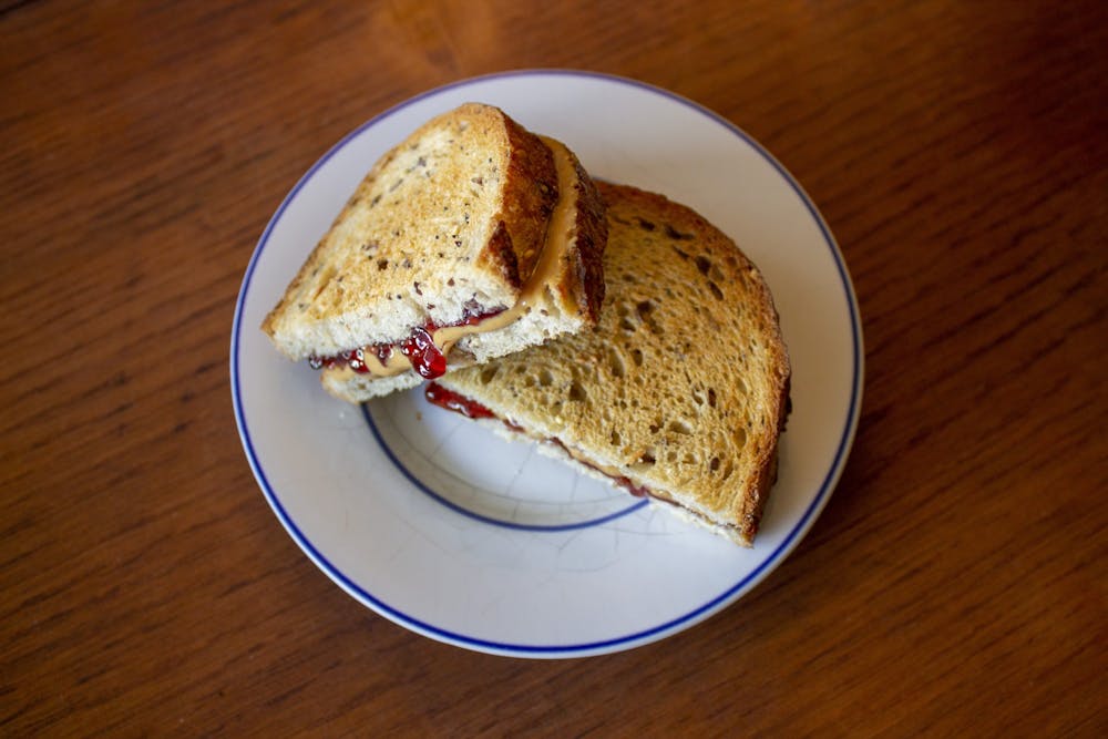 <p>A peanut butter and jelly sandwich sits on a plate.  </p>