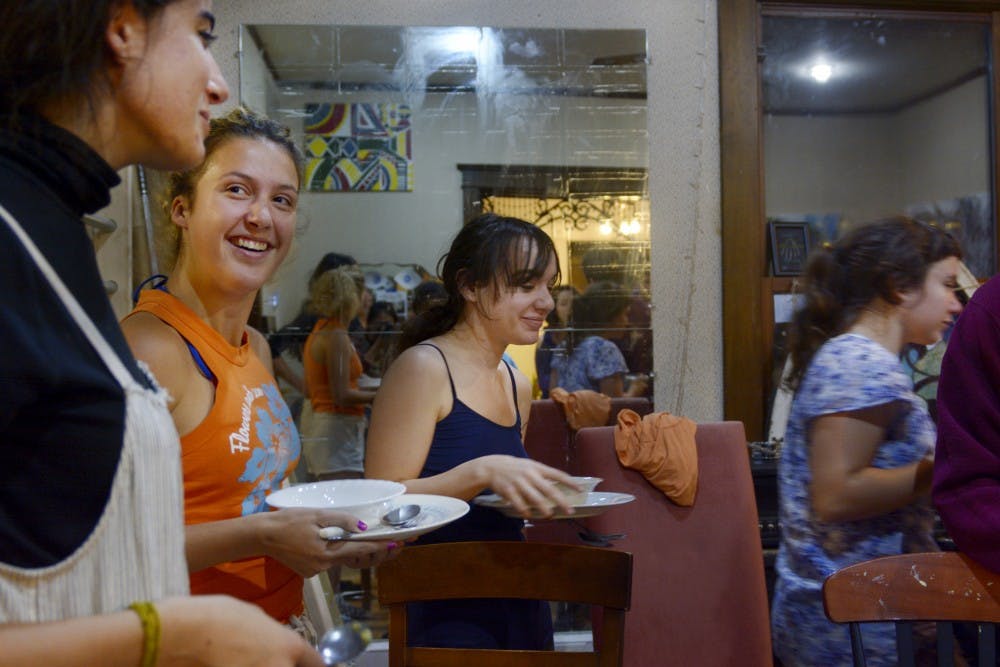 Resident of the Middle Earth co-op living house line up to get dinner, which was prepared by Julia Paglisi and Brett Wisley, two of the house’s residents.