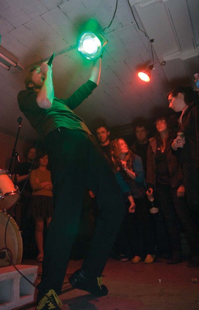 Jackson O'Connel-Barlow of Grand Buffet gets funky with his rhymes under a light at a concert April 4.