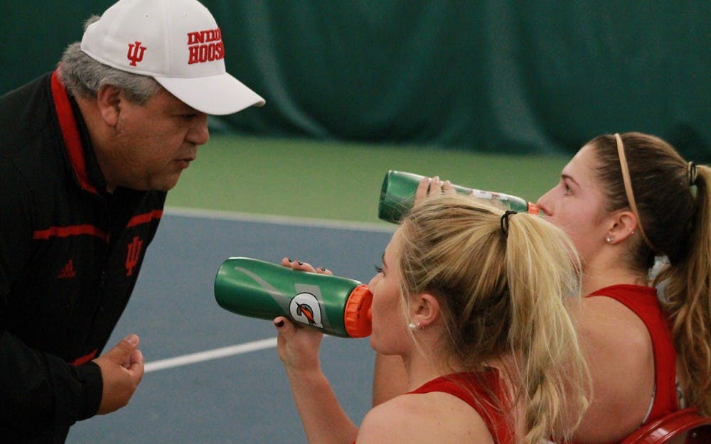 Head coach, Ramiro Azcui, talks with Madison Appel and Natalie Whalen. Appel and Whalen won 7-5 in their doubles matches Saturday morning against DePaul. 
