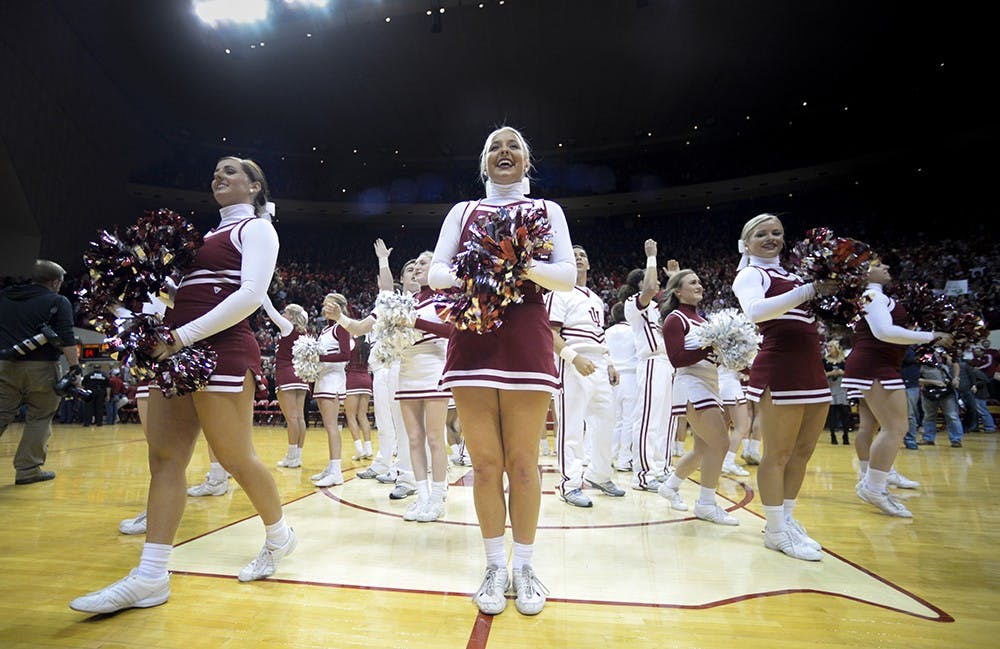 Junior Kori Boe (middle) cheers after the conclusion of IU's game against Maryland on Jan. 22 at Assembly Hall. Boe said because her main job during games is being a cheerleader, not enough people realize they also compete nationally.