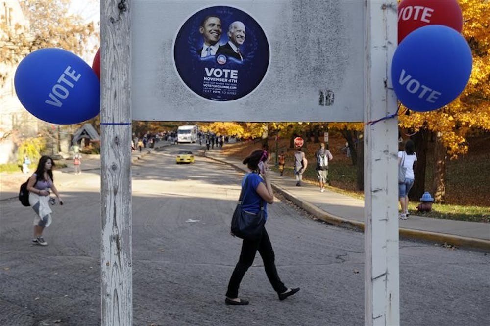 Hundreds of Obama-Biden stickers were stuck to things around campus on Tuesday. Pictured, people make their way to classes Tuesday afternoon south of the IMU.