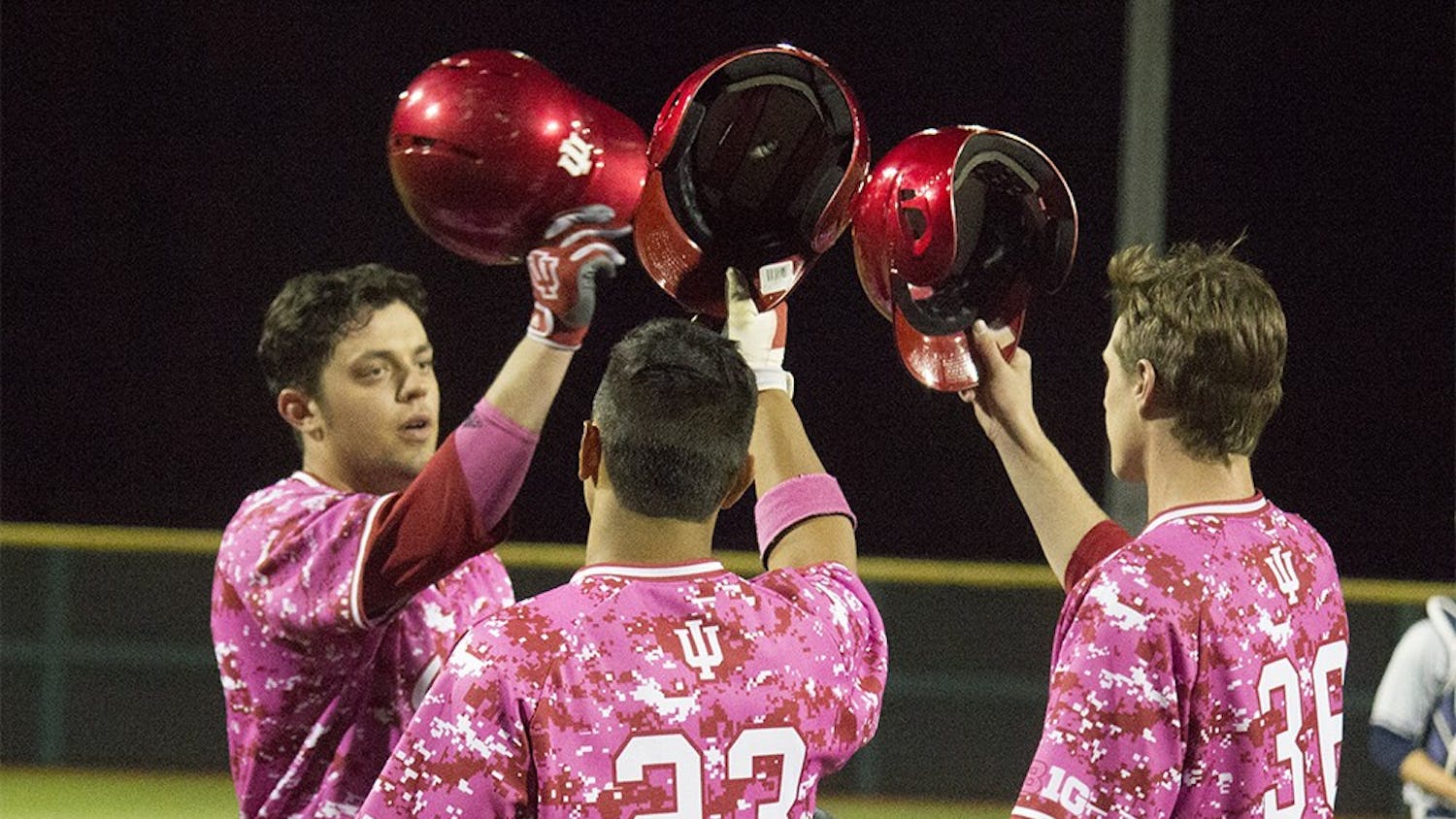 Junior Austin Cangelosi, left, taps helmets with his teammates after scoring his second home run of the night against Butler on Wednesday at Bart Kaufman field. The Hoosiers beat the Bulldogs with a score of 27-1.