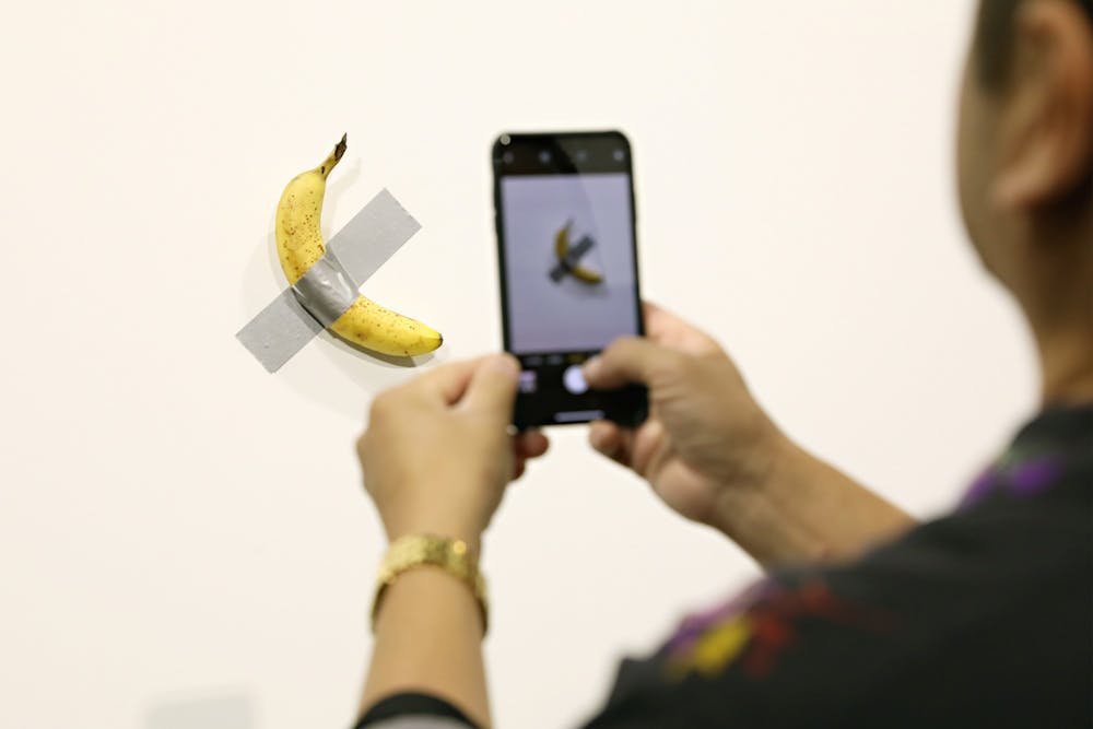 People post in front of Maurizio Cattelan&#x27;s &quot;Comedian&quot; presented by Perrotin Gallery on Dec. 6 at Miami Beach Convention Center in Miami Beach, Florida. 