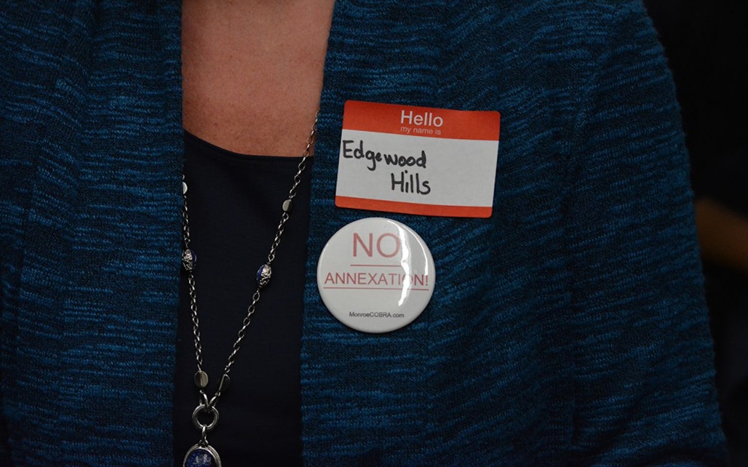 Alison Evans, a resident of Edgewood Hills in annexation area two, wears a pin to protest the proposed new boundaries of Bloomington. Evans was one of about 50 township residents who came Wednesday night's city council meeting.