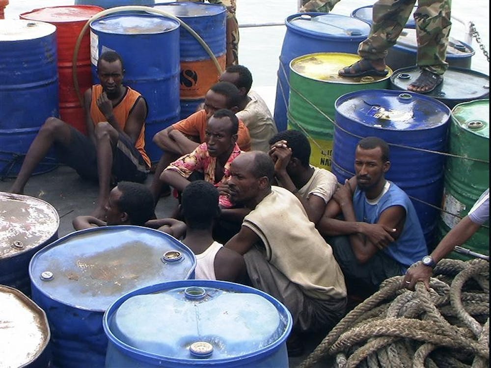 In this Nov. 21, 2008 file photo, Somali pirates held by Puntland police forces, sit in Bassaso, Somalia. They've been described as "noble heros" by sympathetic Somalis, denounced as criminals by critics. But the adjective most used to describe the men holding an American captain off the Horn of Africa is "pirate," a word that conjures images of sword-wielding swashbucklers romanticized by Hollywood. The 21st century reality of ragged Somali fishermen armed with rocket launchers, GPS systems and satellite phones, though, is a far cry from that.