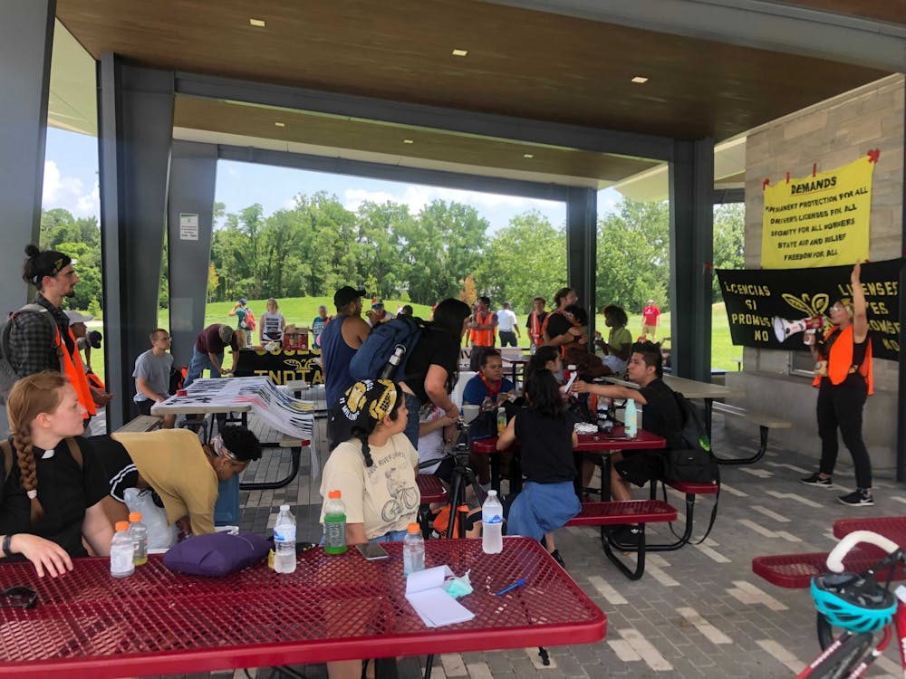 Members and allies of Cosecha Indiana eat and hydrate under a pavilion at Switchyard Park in Bloomington Thursday in preparation for their walk to Sample Gates. The group was gathered in support of undocumented immigrants who cannot obtain a driver&#x27;s license in Indiana.