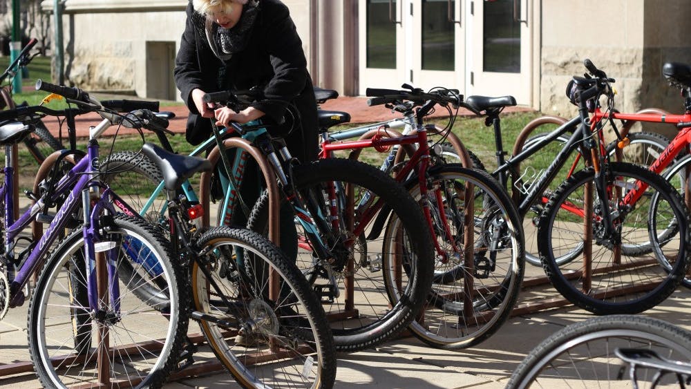Sophomore Sarah Snoddy parks her bike in front of Franklin Hall. A new bike sharing program in Bloomington, called Pace, will begin this spring.