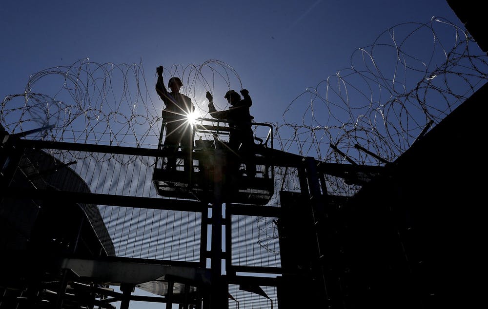 <p>Marines from Camp Pendleton install razor wire at the pedestrian border crossing into Mexico in 2018 in San Ysidro, San Diego.</p>