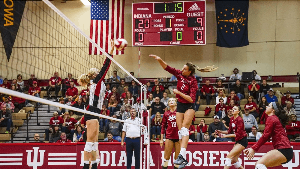 Junior middle blocker Hayden Huybers returns the ball against a Rutgers defender Oct. 13 in University Gym. IU defeated Rutgers, 3-0.