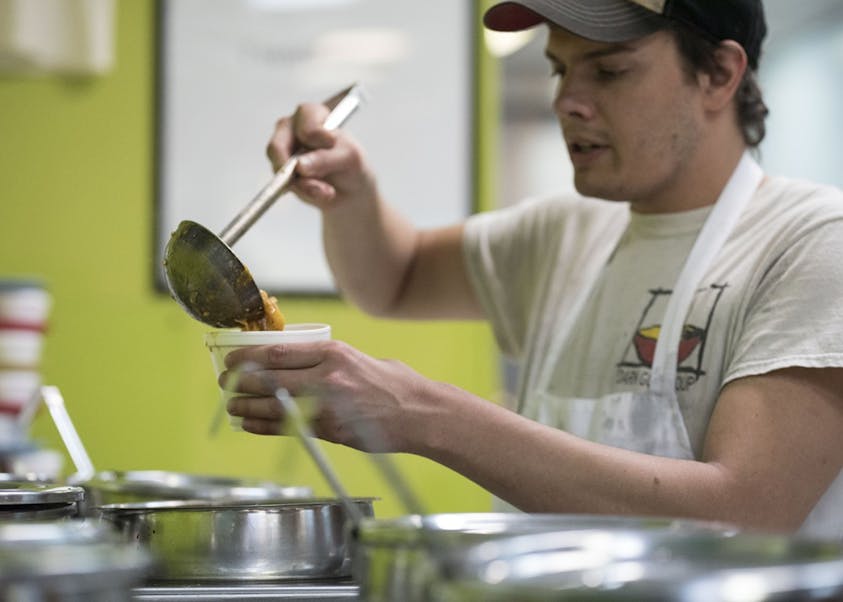 Joseph Nejman serves soup at Darn Good Soup on Tuesday. Darn Good Soup rotates its soups daily to include flavors like cheesy tomatillo, chicken tortilla and lentil spinach.