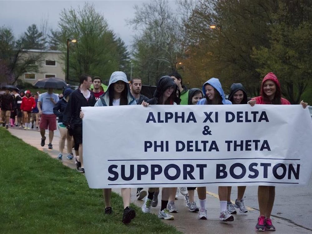 Alpha Xi Delta and Phi Delta Theta members walk in heavy rain on Thursday night in support of the victims of the recent Boston Marathon blasts. The walk stretched from the Alpha Xi Delta house, along North Jordan and to Law Lane.