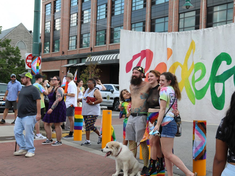 People pose for a picture in front of a big Pridefest sign Aug. 27. The sign was a hotspot for those taking pictures at the event.