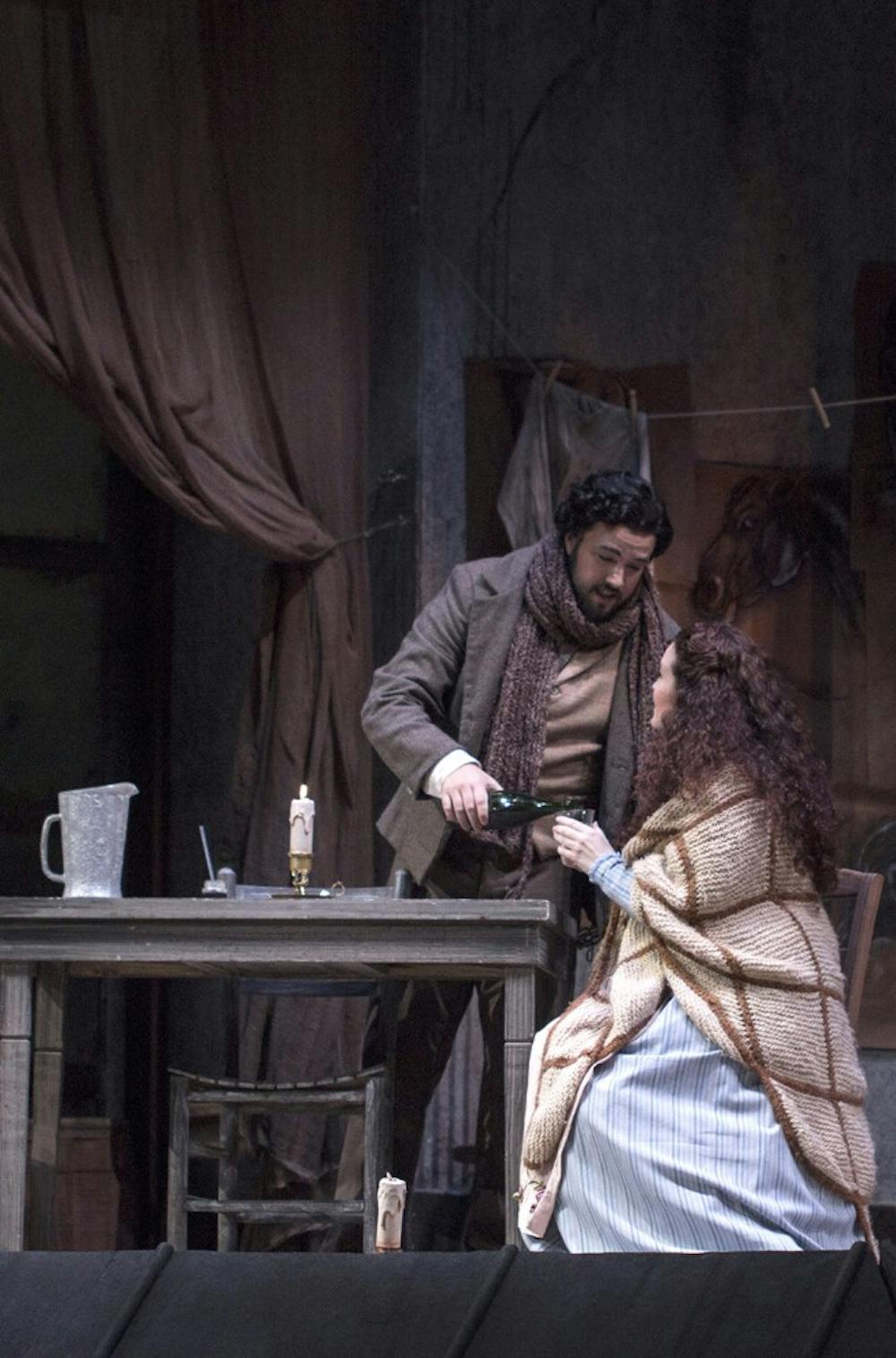 Rodolfo, played by Derrek Stark, pours a drink for Mimi, played by Lacy Sauter, during the dress rehearsal for "La Boheme" on Tuesday at the Musical Arts Center.