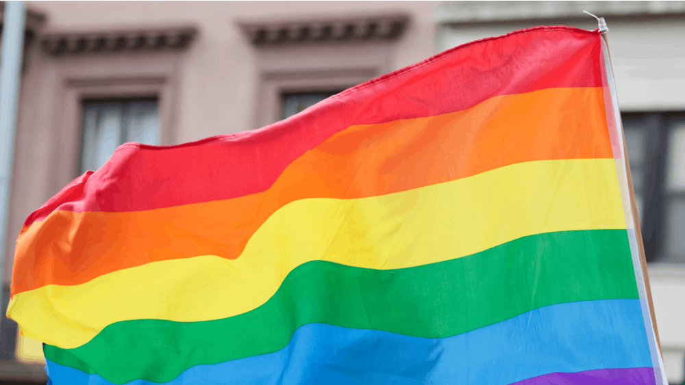 A rainbow flag symbolizing and celebrating gay rights and freedom of expression blows in the wind.