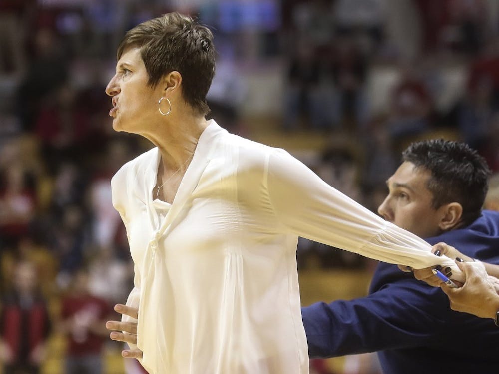 IU women’s basketball head coach Teri Moren gets held back by assistant coaches during the second half of Sunday’s game against Maryland. The Hoosiers fell 76-56. 