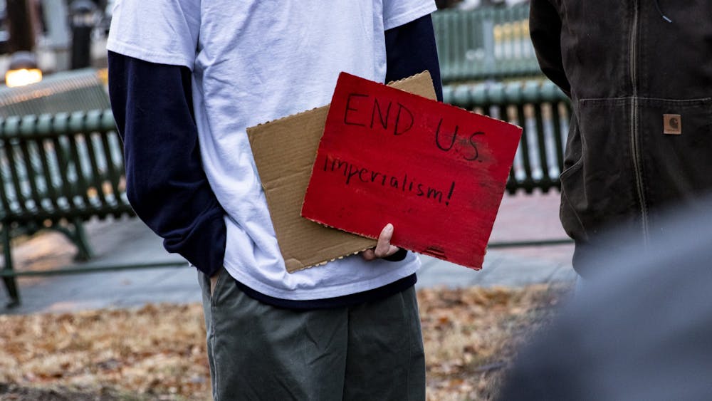 A Democratic Socialists of America member holds a sign during the “No War! Rally” on Jan. 25 in People’s Park. “End U.S. imperialism,” the sign reads.
