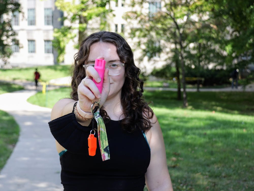 An IU student points her pepper spray Sept. 29, 2021, outside Myers Hall. Carrying pepper spray is one way students take safety precautions on campus. 