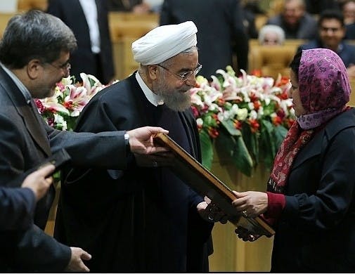 Asma Afsaruddin, right, receives the World Book Prize from Iranian President Hassan Rouhani, center, and a prize committee representative. Afsaruddin is a professor in the Global and International Studies department and was recognized for her book on jihad. 