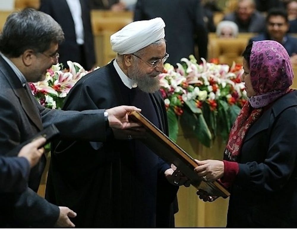 Asma Afsaruddin, right, receives the World Book Prize from Iranian President Hassan Rouhani, center, and a prize committee representative. Afsaruddin is a professor in the Global and International Studies department and was recognized for her book on jihad. 