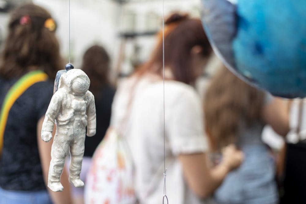 8月30日，在第四街工艺艺术节上，一名陶瓷宇航员悬挂在斯坦·贝克的展位上。<a href=