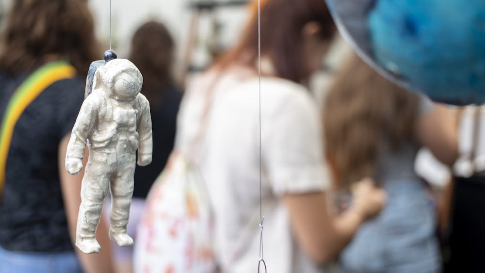 A ceramic astronaut hangs in Stan Baker’s booth at Fourth Street Festival of Arts and Crafts on Aug. 30, 2019. The 2020 festival is now virtual, with showcases available online starting Saturday until Dec. 31.