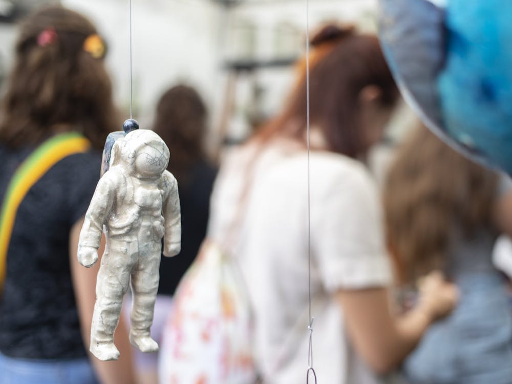 A ceramic astronaut hangs in Stan Baker’s booth at Fourth Street Festival of Arts and Crafts on Aug. 30, 2019. The 2020 festival is now virtual, with showcases available online starting Saturday until Dec. 31.