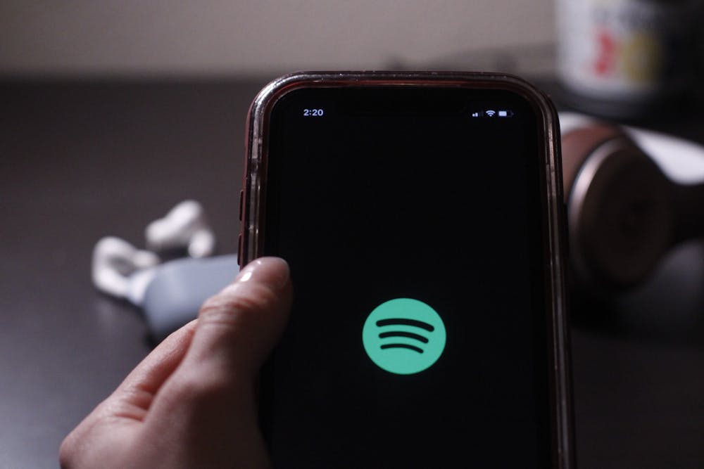 <p>A person opens the Spotify app on a phone Dec. 5, 2021.</p>