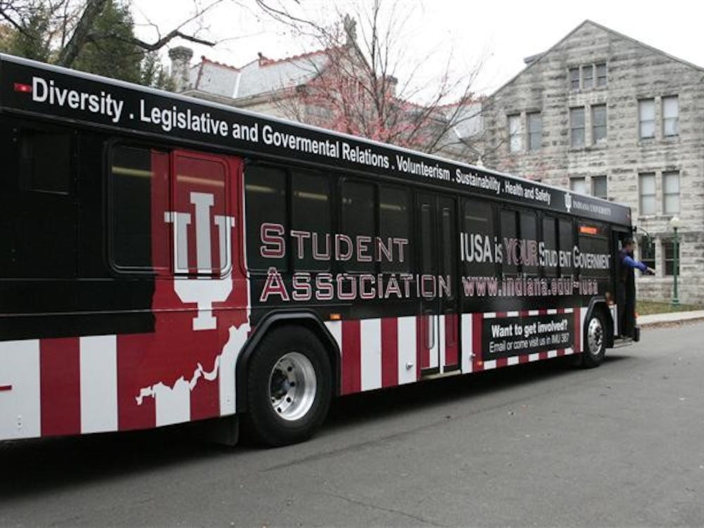 IU Student Association vice president Dan Sloat walks off a newly "wrapped" IUSA bus Sunday behind the IMU. The bus will be launched this week and will have the IUSA advertisement for 12 months.