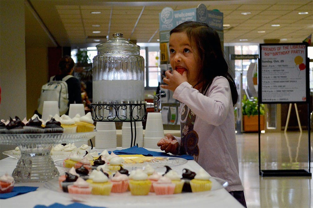Chloe Trinidad eats a free cupcake during the Monroe County Public Library's 50th birthday celebration Sunday afternoon. The library celebrated with food trucks, games, crafts and free cupcakes for their guests.