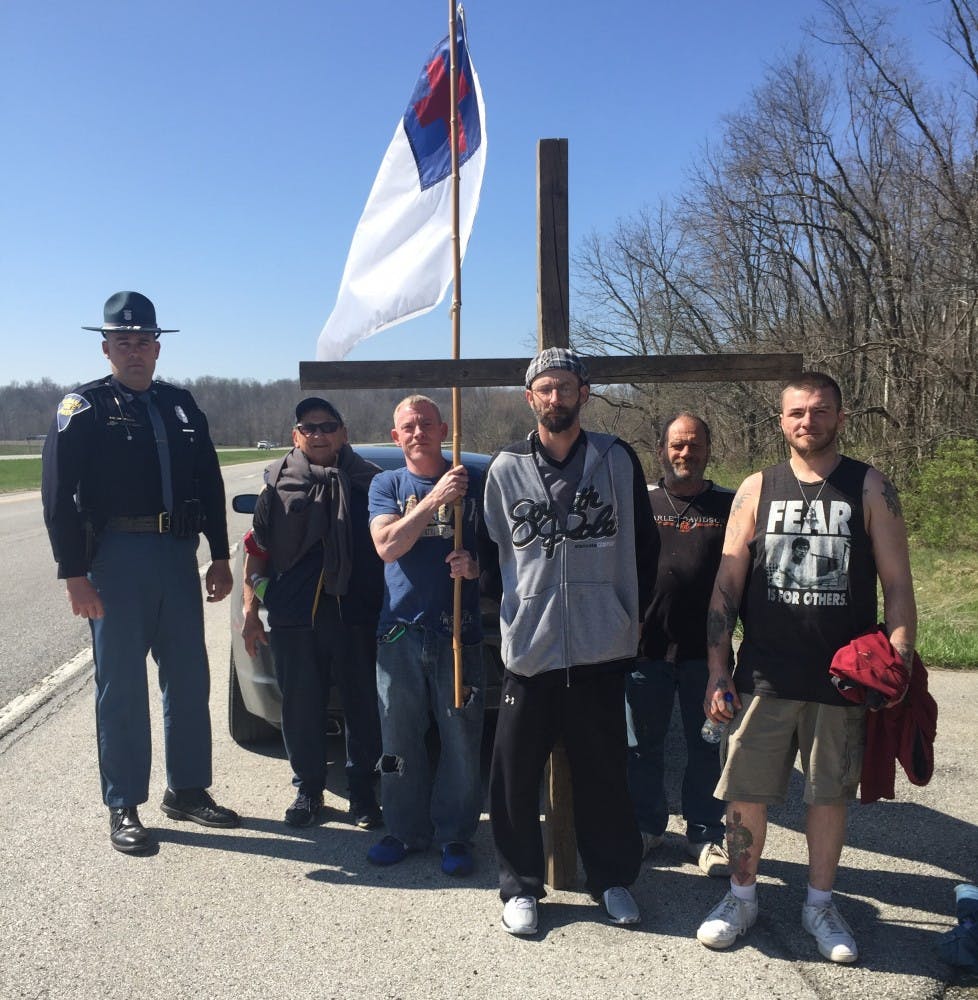 Trooper Dustin Starnes, left, along with the group of people walk toward the Manna Mission, in Martinsville.