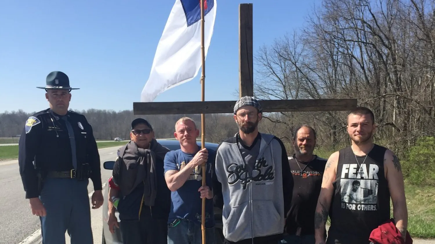 Trooper Dustin Starnes, left, along with the group of people walk toward the Manna Mission, in Martinsville.