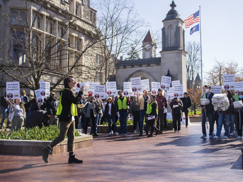 Doctoral candidate Pat Wall leads a chant during the graduate student strike April 14, 2022, at the Sample Gates. The Bloomington Faculty Council voted to assert that no graduate student workers will be fired for striking in a special meeting of the council May 9.