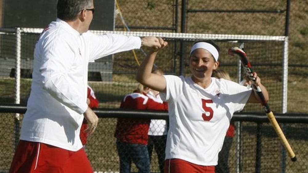 Athletic Director Fred Glass and senior forward Lena Grote give a halftime fist bump before the Hoosiers' 2-1 win Friday at the IU Field Hockey Field. Glass wore the skirt because he told the field hockey coach he would do so if the team beat Louisville on Oct. 5.