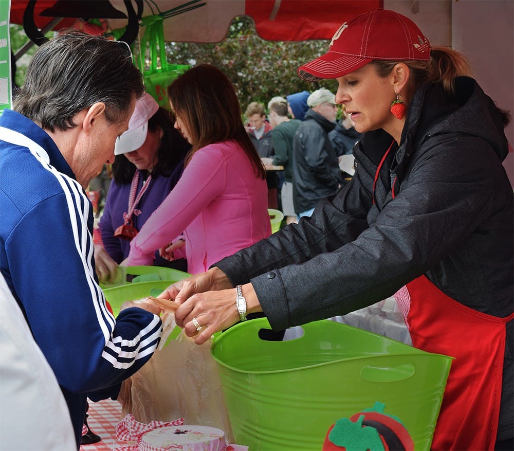 Krista Johns, co-chair of the Strawberry Shortcake Festival, sells Strawberry to customer during the Strawberry Shortcake Festival Thursday afternoon at Courthouse Lawn. This Festival celebrated a tradition 30 years.