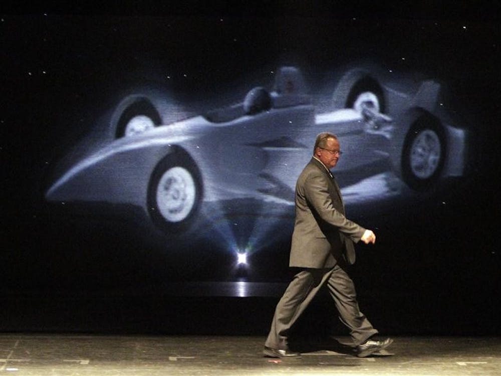 Brian Barnhart, president of competition and racing operations for the Indy Racing League, takes the stage in front of a hologram of the new Dallara chassis that will be used starting in the 2012 season,  during an announcement in Indianapolis on Wednesday.