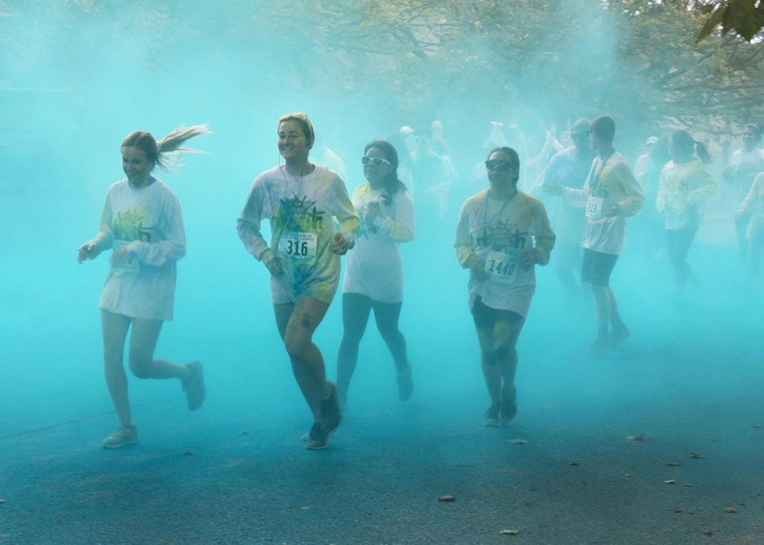 Participants run through blue powder at the last color station of the Jill Behrman Color the Campus 5K Run/Walk on Saturday. This was the 18th running of the JB5K.