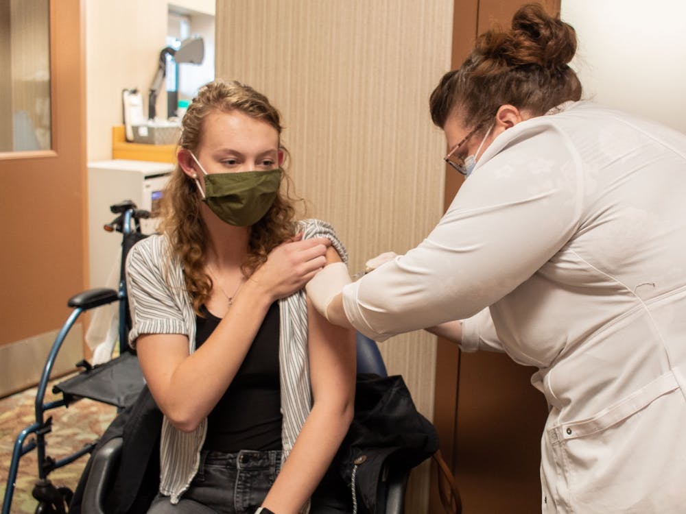 印第安纳大学二年级学生Kathryn Mick 3月22日在大学购物路上的Kroger接受了辉瑞的第一轮疫苗。“我从来没有像现在这样为能拍到一张照片而激动过。”她说。