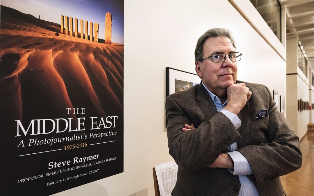 Professor Steve Raymer stands at the front of his exhibition, "The Middle East: A Photojournalist's Perspective," on view through March 12 at the Mathers Museum of World Cultures. The images are from Raymer's travels in the Middle East and depict a variety of countries, landscapes and cultural groups.