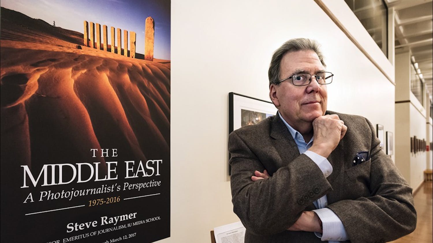 Professor Steve Raymer stands at the front of his exhibition, "The Middle East: A Photojournalist's Perspective," on view through March 12 at the Mathers Museum of World Cultures. The images are from Raymer's travels in the Middle East and depict a variety of countries, landscapes and cultural groups.